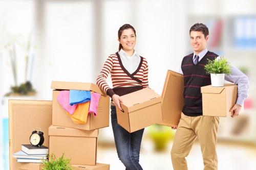 Professional movers transporting furniture during a Greenwich same day removal