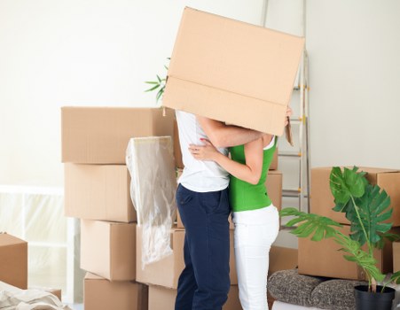 Removal team handling furniture in a London flat